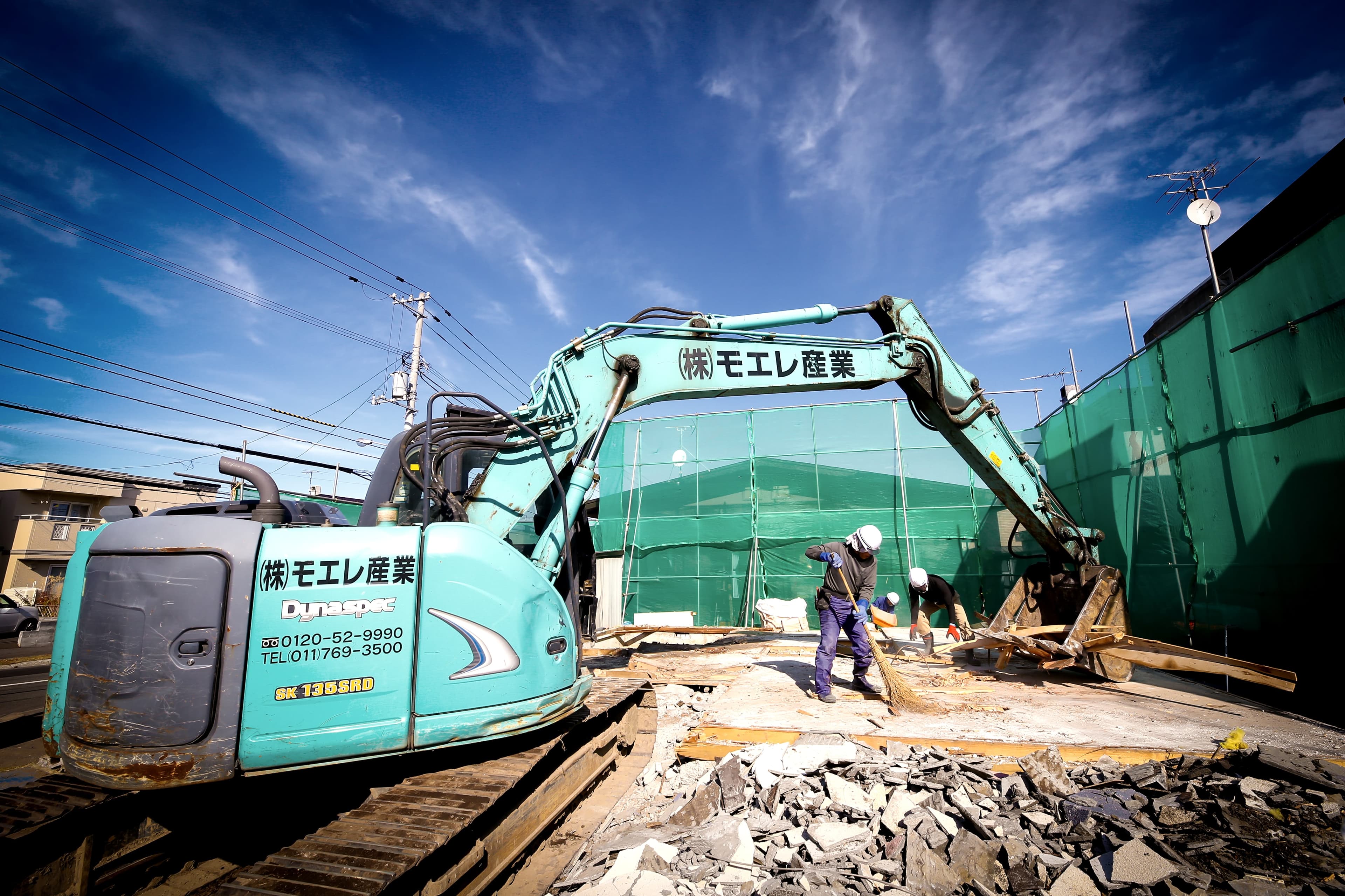 養生のある解体現場で作業する重機